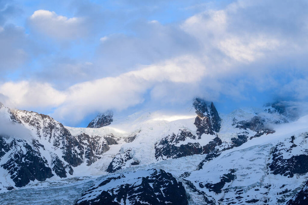 Bu manzara fotoğrafı Avrupa 'da, Fransa' da, Alpler 'de, yazın Chamonix' e doğru çekildi. Mont Blanc du Tacul 'un bulutlar ve ışıklarla çevrili olduğunu görüyoruz.. - Fotoğraf, Görsel