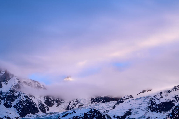Deze landschapsfoto is genomen in Europa, in Frankrijk, in de Alpen, richting Chamonix, in de zomer. We zien de roze wolken rond de Mont Blanc du Tacul bewegen. - Foto, afbeelding