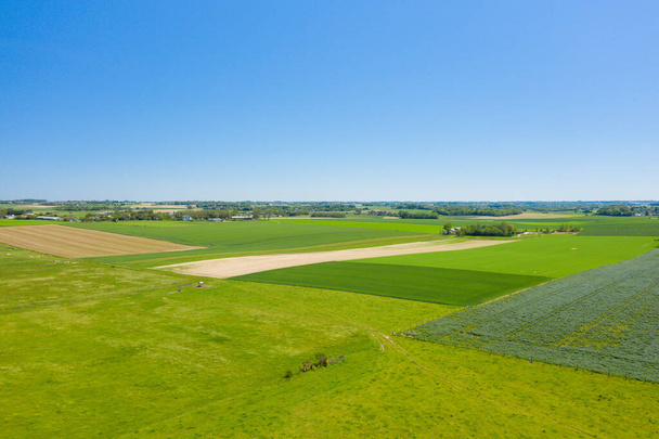 Это пейзажное фото было сделано в Европе, Франции, Нормандии, недалеко от Довиля, летом. Мы видим сельскую местность Нормандии и ее поля льна и ячменя, под солнцем. - Фото, изображение