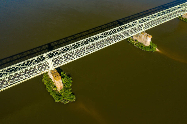 Ez a tájkép Európában készült, Franciaországban, a Középső régióban, a Loiret-ben, nyáron. Látjuk Sully sur Loire városának gyalogos hídját a Nap alatt.. - Fotó, kép