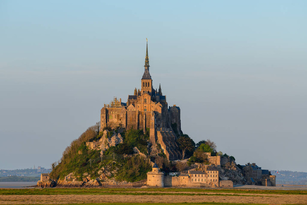 Cette photo de paysage a été prise en Europe, France, Normandie, Manche, au printemps. On voit Le Mont-Saint-Michel au coucher du soleil, sous le soleil. - Photo, image