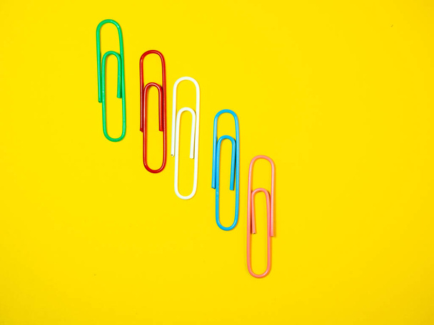 Large multi-colored paper clips. Paperclip of documents. Desktop. Bright stationer - Zdjęcie, obraz