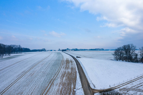Tato fotografie krajiny byla pořízena v Evropě, Francii, Normandii, mezi Dieppe a Fecamp, v zimě. Vidíme tam cestu, která prochází krajinou pod sněhem, pod sluncem. - Fotografie, Obrázek