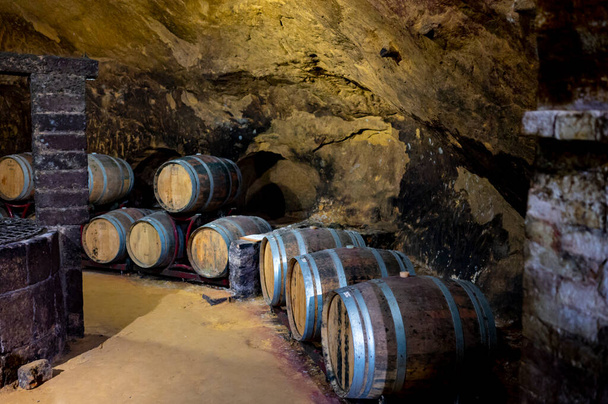 Bodegas subterráneas medievales con barricas de vino tinto viejo para el envejecimiento del vino nobile di Montepulciano en el casco antiguo en la colina Montepulciano en Toscana, Italia - Foto, imagen