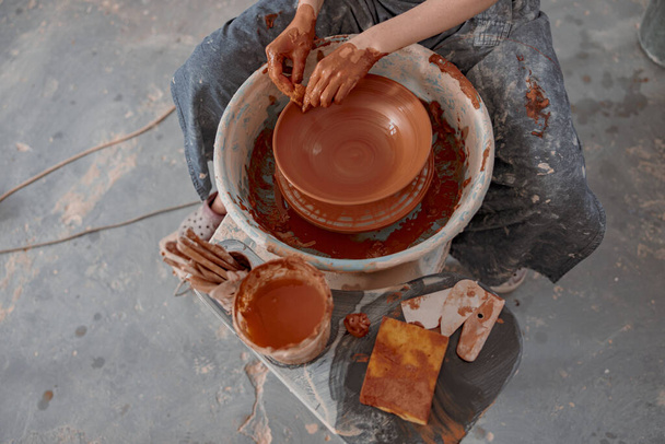 Handmade artist creating earthen bowl on circle in pottery workshop - Valokuva, kuva