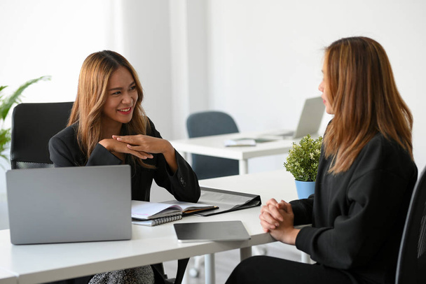 成功したアジアの女性マネージャーは、現代的なオフィスの職場で彼女のマーケティング従業員と話す. - 写真・画像