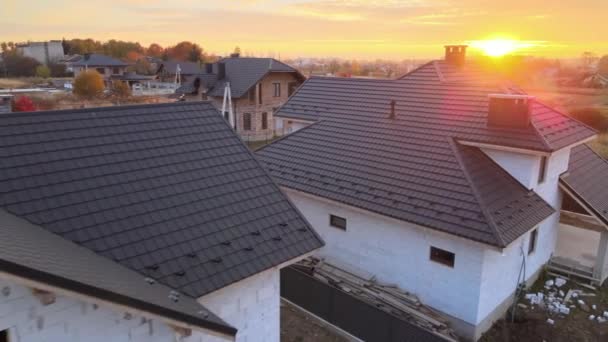 Vista aérea da casa inacabada com paredes de concreto leve aerado e estrutura de telhado de madeira coberta com telhas metálicas em construção - Filmagem, Vídeo