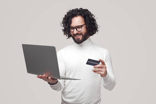 Smiling man making online purchase with plastic card - Foto, Bild
