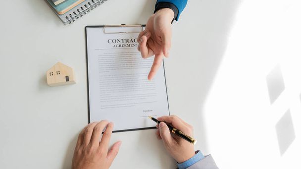 Real estate agents offer home or homeownership insurance to their clients. at the modern wooden table Signing of sales and lease agreements Broker/Seller/Dealer Concept - Foto, Bild