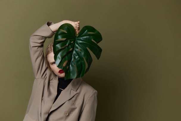 λαμπερό γυναίκα πράσινο παλτό φύλλο παλάμη φωτεινό μακιγιάζ απομονωμένο φόντο - Φωτογραφία, εικόνα