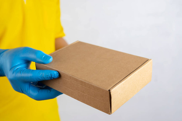 Delivery man holding cardboard boxes in medical rubber gloves and mask. copy space. Fast and free Delivery transport . Online shopping and Express delivery . Quarantine - Фото, изображение