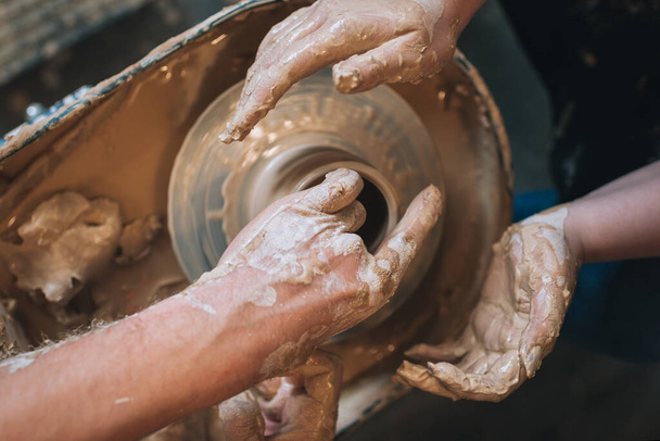 Clay modeling hands on a potter's wheel. Handmade. Ceramic tableware. - Foto, afbeelding