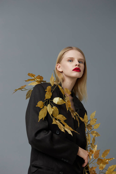 pretty woman golden leaves black blazer red lips studio model unaltered - Foto, afbeelding