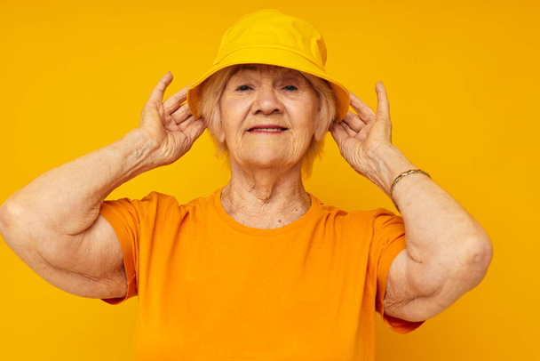 Photo of retired old lady happy lifestyle in a yellow headdress yellow background - Fotografie, Obrázek