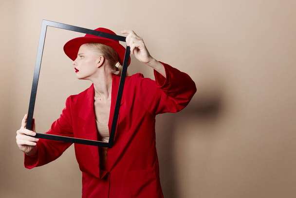 portret van een vrouw met houten frame poseren rood pak Lifestyle poseren - Foto, afbeelding
