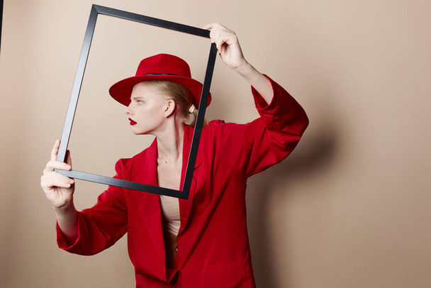 pretty woman with wooden frame posing red suit studio model unaltered - 写真・画像