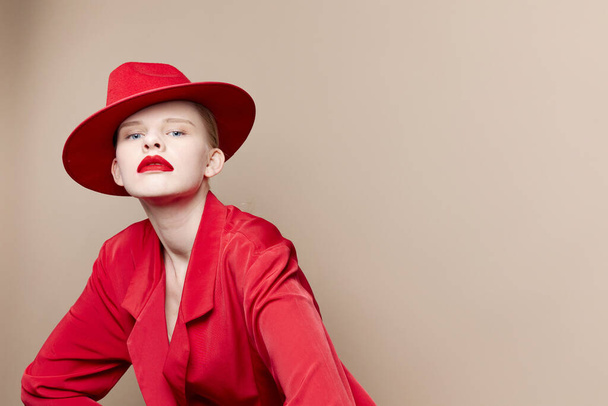 bonita mujer chaqueta roja y sombrero labios rojos modelo de estudio de moda inalterado - Foto, imagen