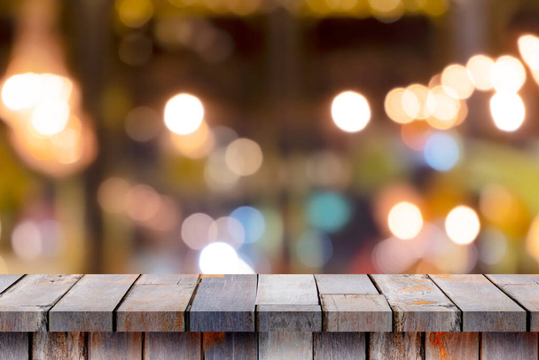 Tavolo in legno vuoto davanti a sfondo sfocato, prospettiva. Legno marrone sfocato in una caffetteria: può essere utilizzato per visualizzare o modificare i prodotti. Finto per una fiera - Foto, immagini