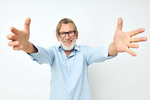 old man in blue shirts gestures with his hands isolated background - Fotoğraf, Görsel