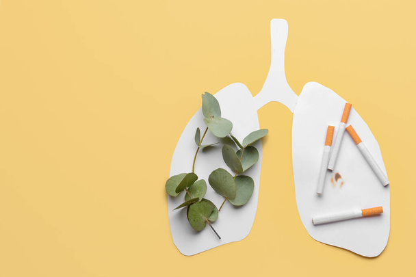 Paper human lungs with green leaves and cigarettes on color background - Valokuva, kuva