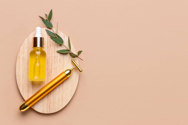 Face massage roller with essential oil on color background - Foto, Bild