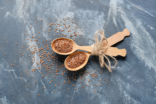 Spoons with flax seeds on color background - Fotografie, Obrázek