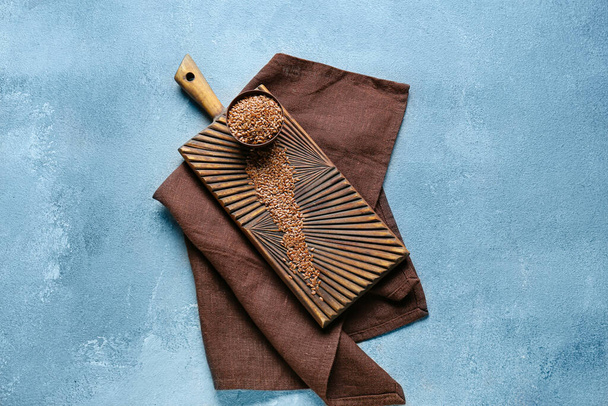 Bol et planche avec graines de lin crues sur fond de couleur - Photo, image