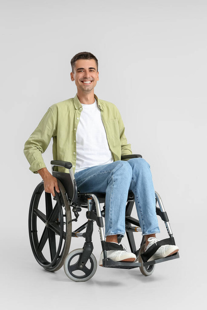 Nuori mies pyörätuolissa kevyellä taustalla - Valokuva, kuva