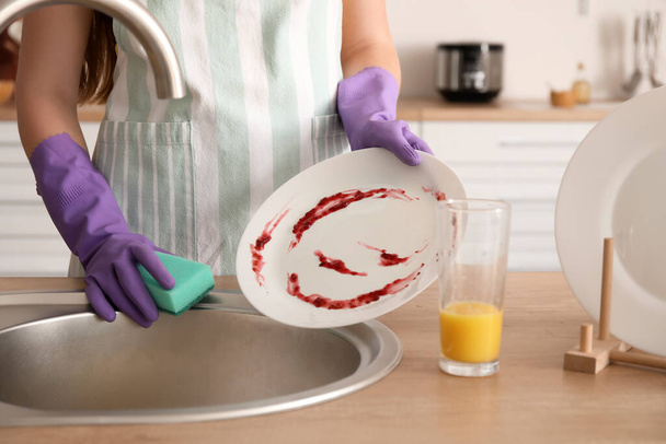 Giovane donna che lava i piatti a casa
 - Foto, immagini