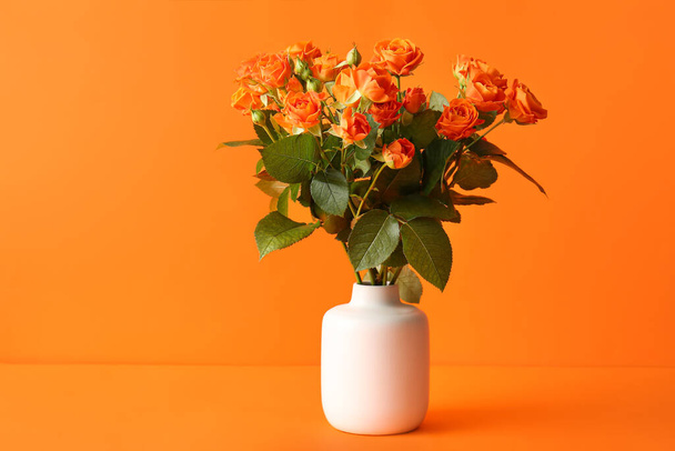 Vase with beautiful orange roses on color background - Fotoğraf, Görsel