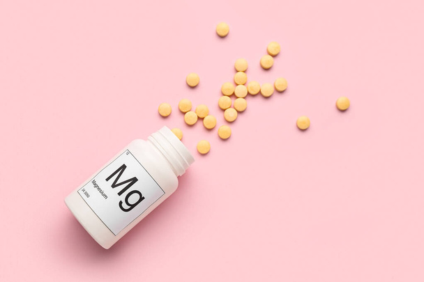 Bottle of magnesium pills on pink background - Фото, изображение