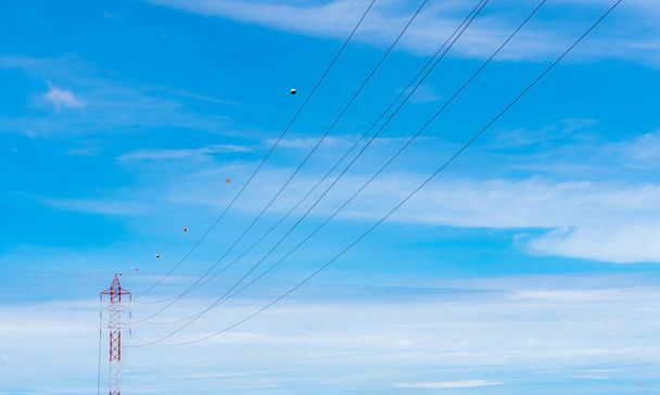 High voltage power lines against blue sky. High voltage electric transmission tower. Electricity pylon and electric power transmission lines. High Voltage tower provide power supply. Power and energy. - Photo, image