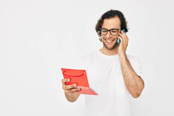 Vrolijke man rode notitieblok telefoon communicatie Lifestyle ongewijzigd - Foto, afbeelding