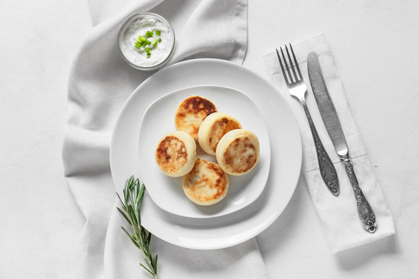 Plate with tasty cottage cheese pancakes and sauce on white background - Foto, Bild