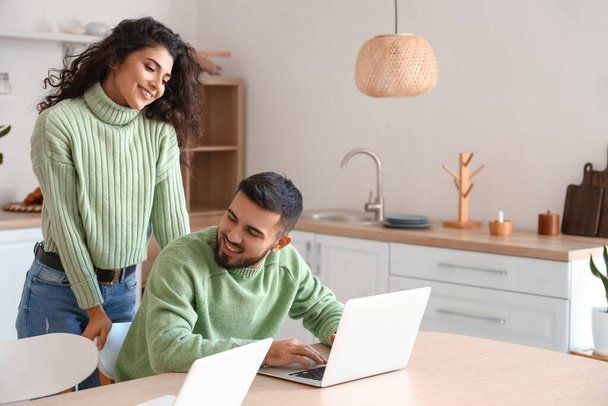 Feliz joven pareja de freelancers con ordenadores portátiles en casa - Foto, imagen
