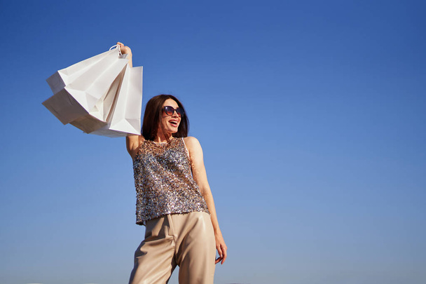 Happy girl holds shopping bags. Sales or discount time - Foto, Imagen