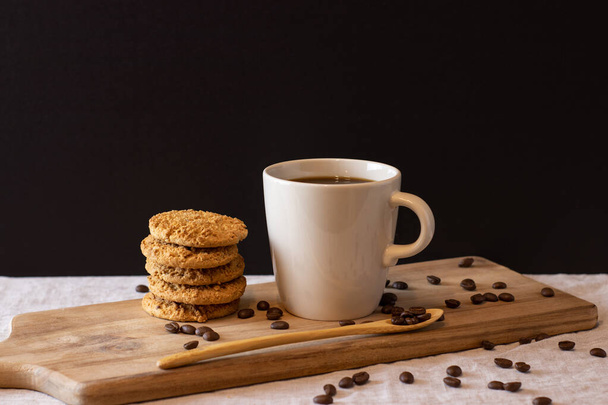 Latte met koekjes op houten staander en koffiebonen. Geïsoleerde achtergrond - Foto, afbeelding