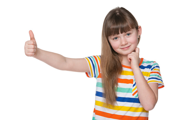 klein meisje houdt haar duim omhoog - Foto, afbeelding