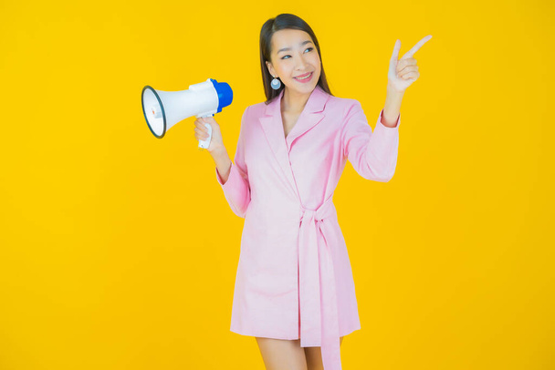 Portrait beautiful young asian woman smile with megaphone on color background - Photo, Image