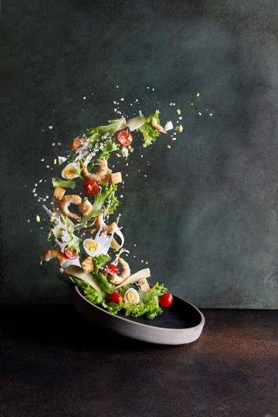 caesar salad on the table with ingredients with shrimp - Фото, изображение