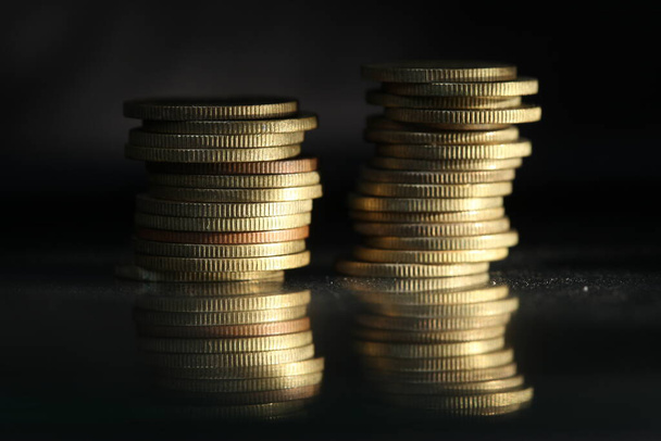 A vertical shot of a pile of golden coins and copper coins. - Fotó, kép