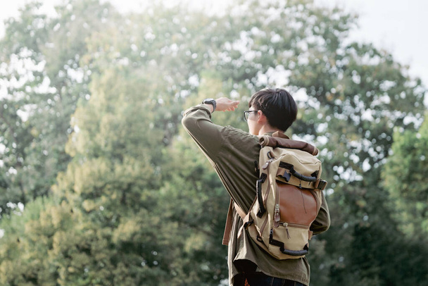 Junger Mann läuft mit Rucksack über natürlichen Hintergrund. - Foto, Bild