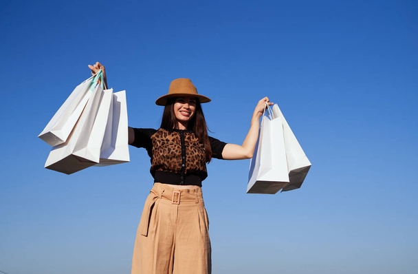 Jovem shopaholic mulher dançando com sacos de compras ao ar livre - Foto, Imagem