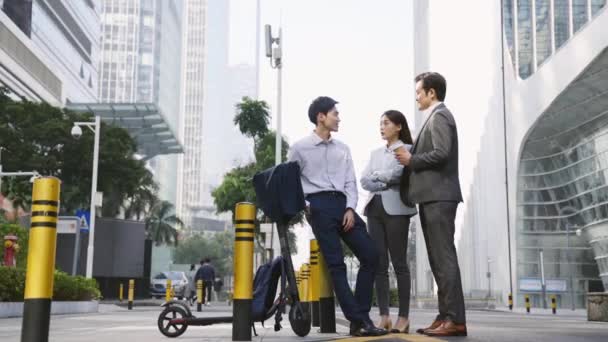 tres asiático empresarios de pie en la calle hablando en el centro de negocios distrito - Metraje, vídeo