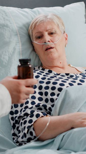 Vanha potilas saa pullon pillereitä toipumiseen lääkäriltä - Valokuva, kuva
