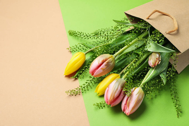 Χάρτινη τσάντα με λουλούδια σε φόντο δύο τόνων - Φωτογραφία, εικόνα