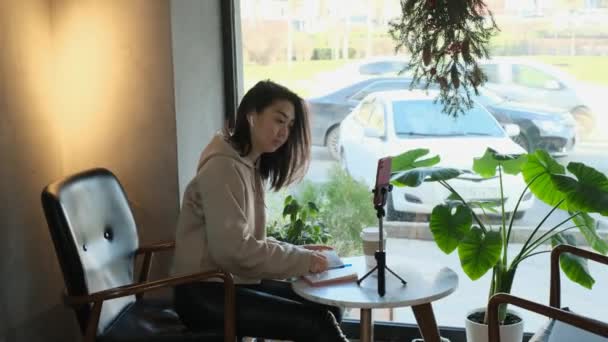 Asian female freelancer working in a cafe - Materiał filmowy, wideo