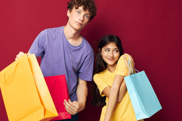 portrait of a man and a woman colorful bags shopping fun isolated background unaltered - Photo, image