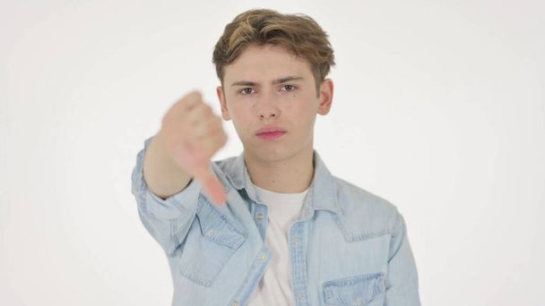 Polegares para baixo gestos por homem jovem em fundo branco - Foto, Imagem
