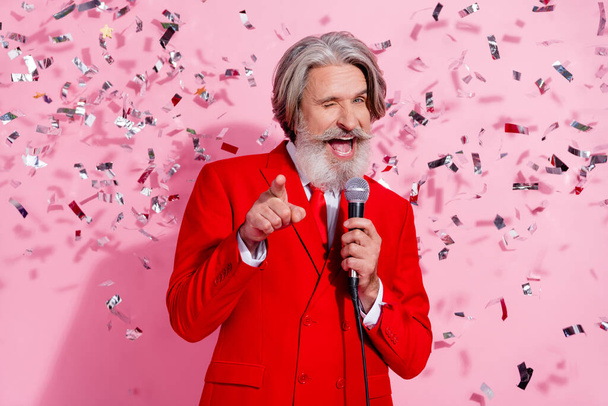Portrait of attractive cheerful cool trendy grey-haired man mc singing song winking anniversary isolated over pink pastel color background. - Foto, Bild
